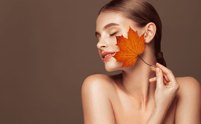 Female model holding autumn leaf