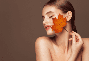Female model holding autumn leaf Female model holding autumn leaf