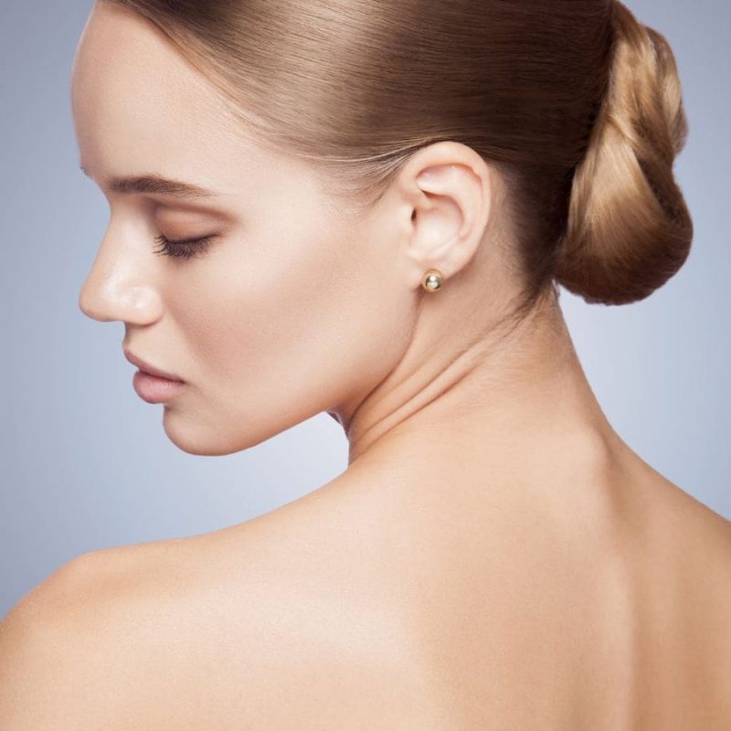Close up of a woman looking over her shoulder with smooth radiant skin